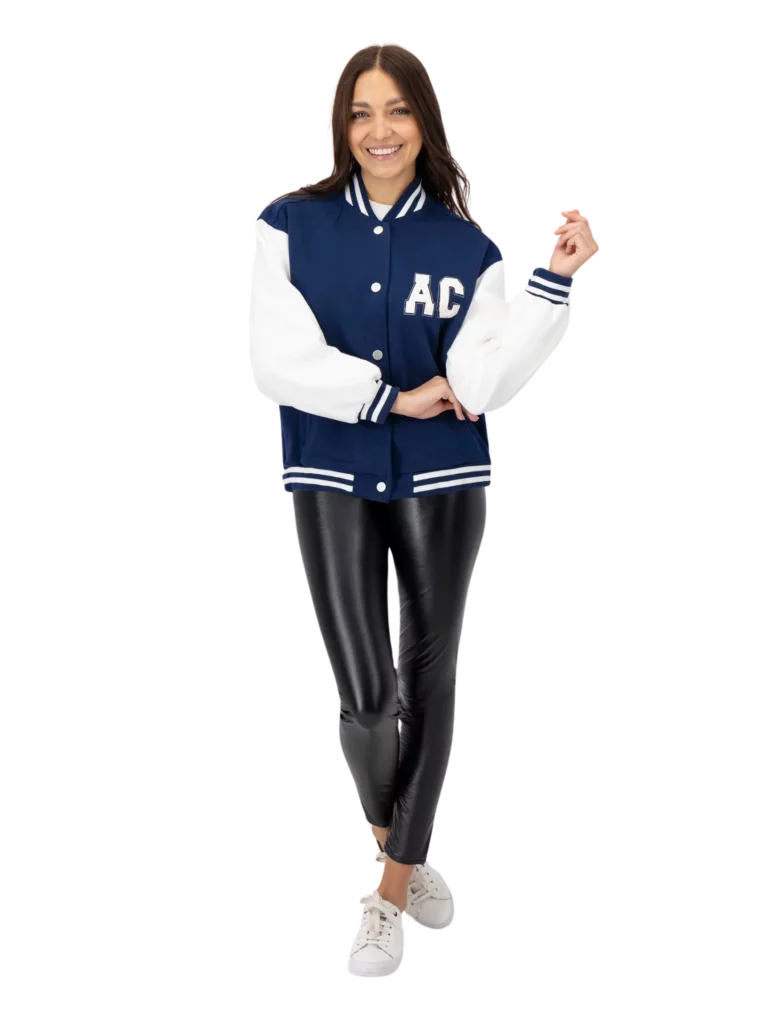 Mujer usando suéter color azul con blanco, pantalones negros y tenis blancos.