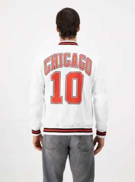 Hombre de espaldas usando sudadera beisbolera color blanco que dice CHICAGO 10 en letras naranjas.
