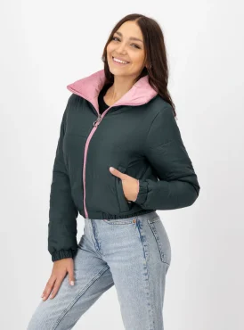 Mujer sonriendo usando chamarra color gris oscuro con rosa.